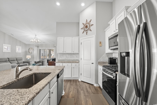 kitchen featuring sink, white cabinetry, light stone counters, dark hardwood / wood-style floors, and stainless steel appliances