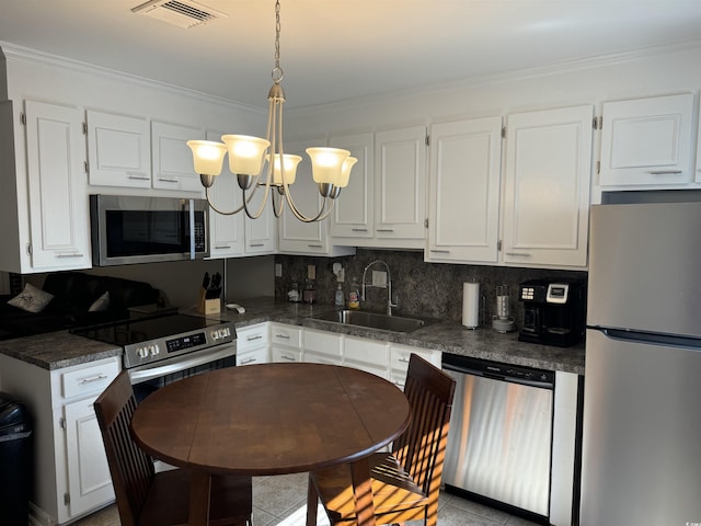 kitchen featuring sink, white cabinetry, ornamental molding, stainless steel appliances, and backsplash