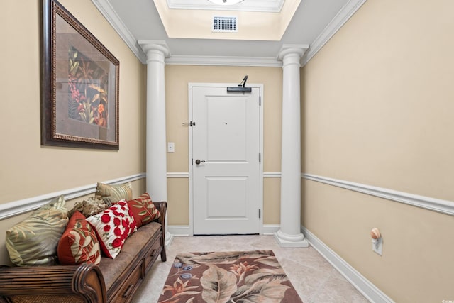 interior space with a raised ceiling, ornamental molding, and ornate columns