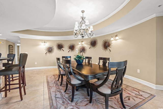 tiled dining space with a tray ceiling, crown molding, an inviting chandelier, and decorative columns