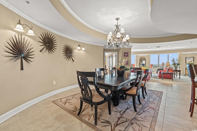 dining space with a tray ceiling, ornamental molding, light tile patterned flooring, and an inviting chandelier