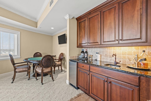 kitchen with sink, ornamental molding, tasteful backsplash, and dark stone counters