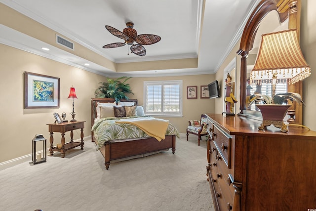 carpeted bedroom featuring a tray ceiling and ornamental molding