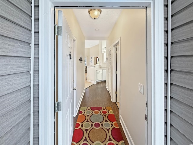 hallway with baseboards and dark wood-style flooring