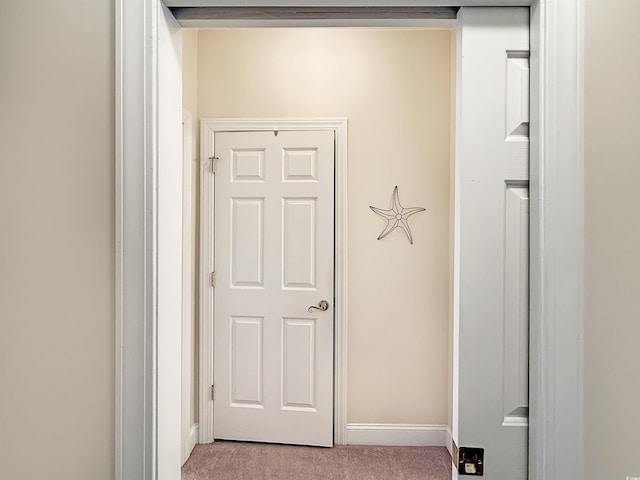 hallway with carpet floors and baseboards