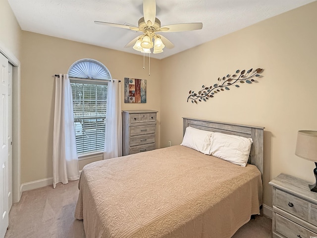 bedroom with baseboards, ceiling fan, and light carpet