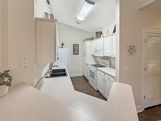 kitchen featuring white cabinetry, white appliances, lofted ceiling, and sink