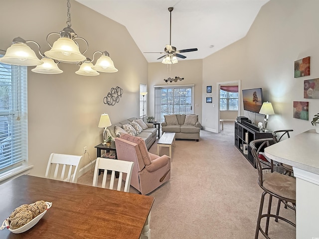 living area featuring light colored carpet, a ceiling fan, baseboards, and high vaulted ceiling
