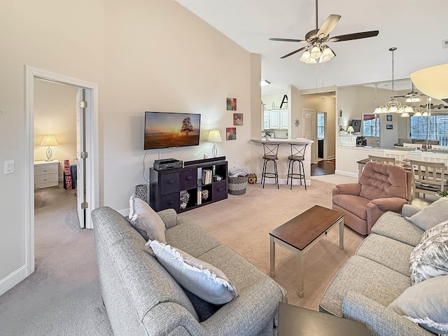 living room with baseboards, a ceiling fan, carpet, and high vaulted ceiling