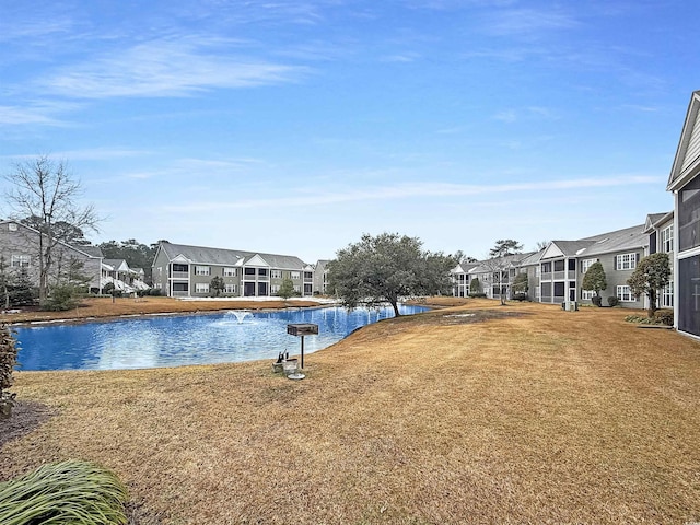 view of pool with a yard and a water view