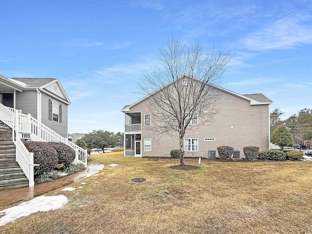 view of side of property with a sunroom and a lawn