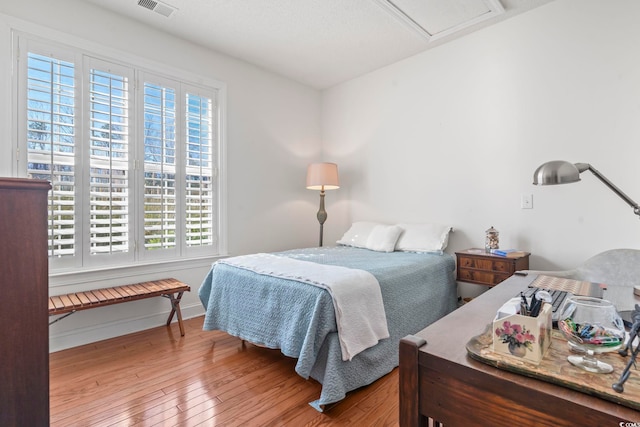 bedroom with hardwood / wood-style floors and multiple windows