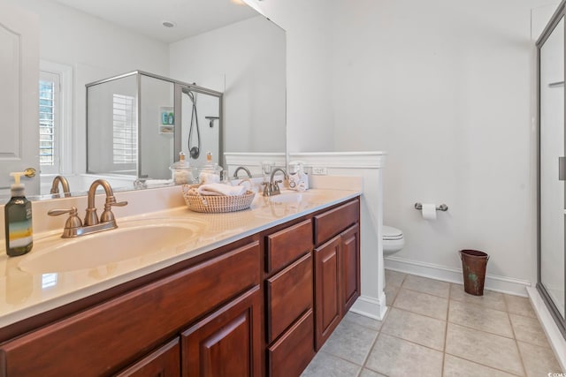 bathroom with vanity, toilet, tile patterned flooring, and a shower with door