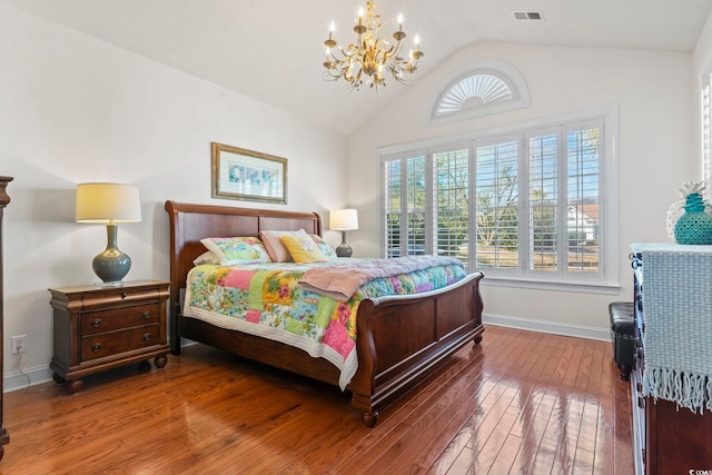 bedroom featuring vaulted ceiling, hardwood / wood-style floors, and a notable chandelier