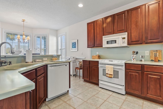 kitchen with sink, white appliances, a textured ceiling, decorative light fixtures, and a chandelier