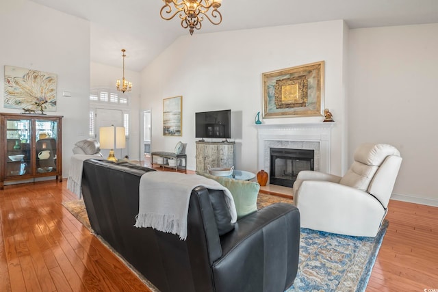 living room featuring hardwood / wood-style flooring, a notable chandelier, and a fireplace