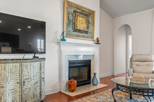 living room with lofted ceiling, hardwood / wood-style floors, and a fireplace