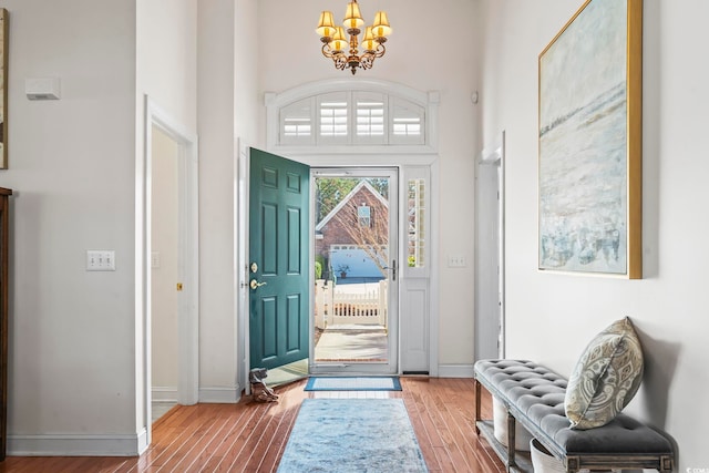 entryway featuring hardwood / wood-style flooring, a chandelier, and a high ceiling