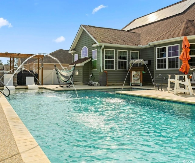 view of swimming pool with pool water feature, a pergola, and a patio area