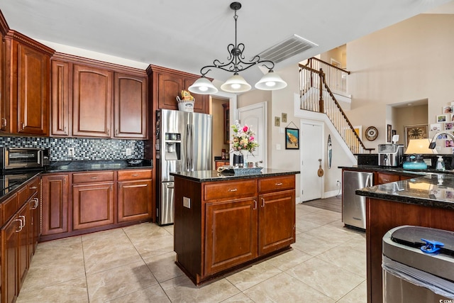 kitchen with decorative light fixtures, stainless steel fridge with ice dispenser, light tile patterned floors, a kitchen island, and decorative backsplash