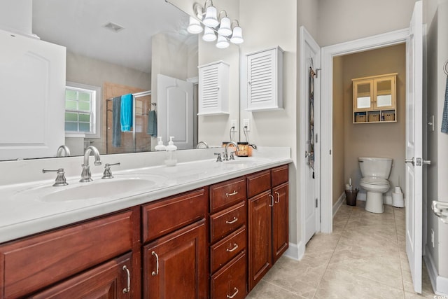 bathroom with a shower with door, vanity, tile patterned floors, and toilet