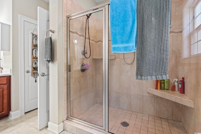 bathroom with an enclosed shower, vanity, and tile patterned floors