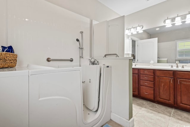 bathroom featuring vanity, washer / dryer, and tile patterned flooring