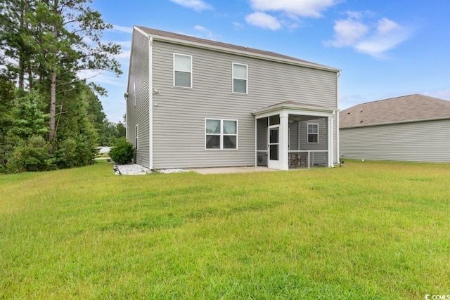 rear view of house featuring a yard and a sunroom