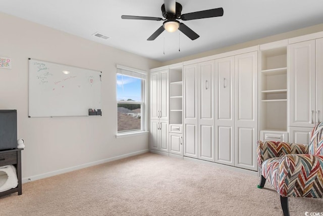 living area with ceiling fan and light carpet