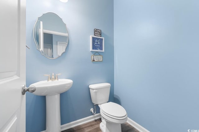 bathroom featuring sink, wood-type flooring, and toilet