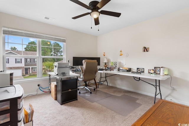 carpeted office space featuring ceiling fan