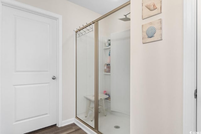 bathroom with hardwood / wood-style flooring and an enclosed shower