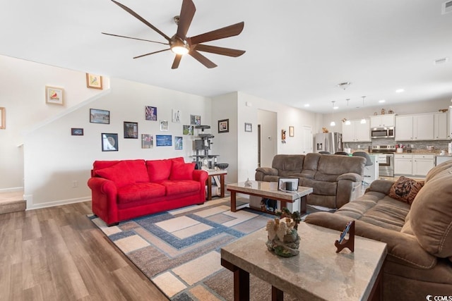 living room with ceiling fan and light wood-type flooring