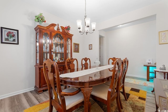 dining area featuring hardwood / wood-style floors and a chandelier