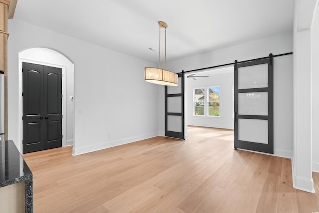 entryway with a barn door and light hardwood / wood-style flooring