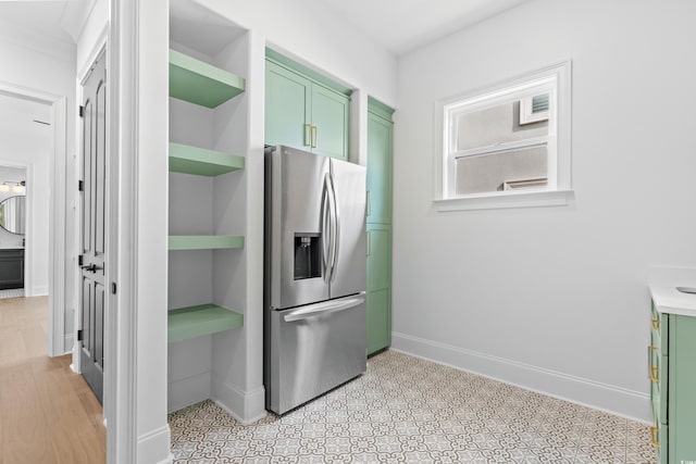 kitchen with stainless steel fridge and green cabinets