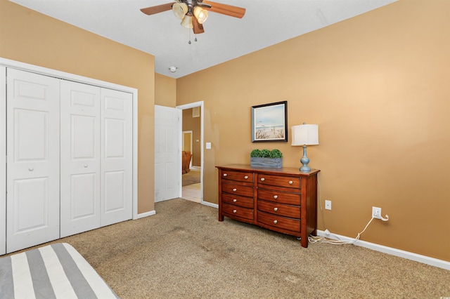 bedroom with ceiling fan, light colored carpet, and a closet