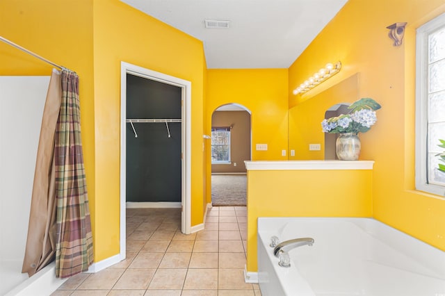 bathroom featuring tile patterned flooring, a wealth of natural light, and separate shower and tub