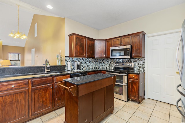 kitchen with sink, light tile patterned floors, appliances with stainless steel finishes, tasteful backsplash, and a kitchen island