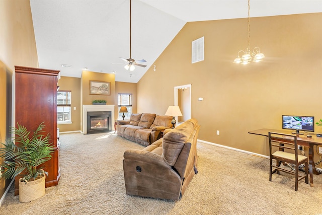 carpeted living room featuring ceiling fan with notable chandelier and high vaulted ceiling