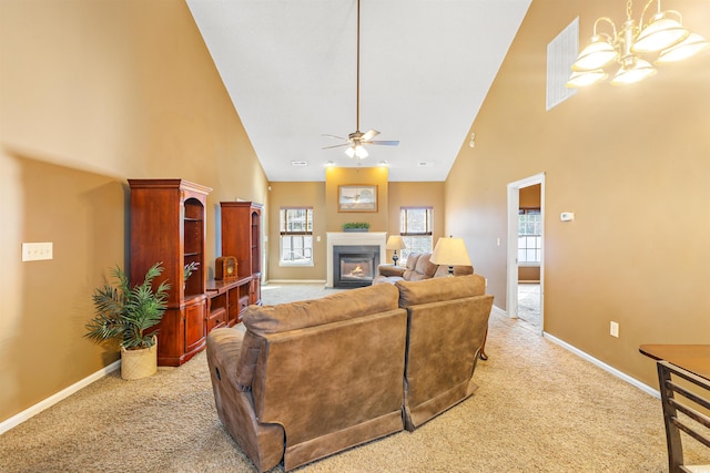 living room featuring ceiling fan with notable chandelier, light carpet, a wealth of natural light, and high vaulted ceiling