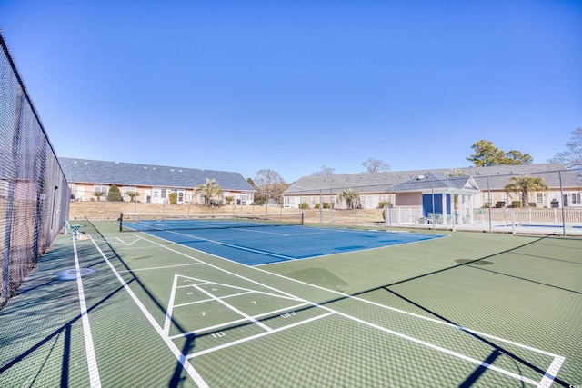 view of tennis court with a residential view, shuffleboard, and fence