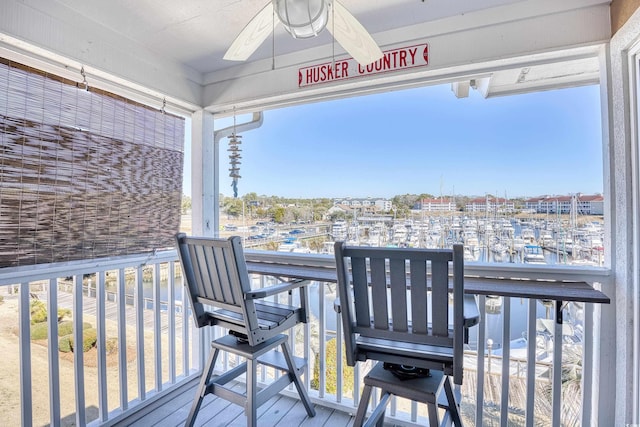 wooden terrace featuring a water view and a ceiling fan