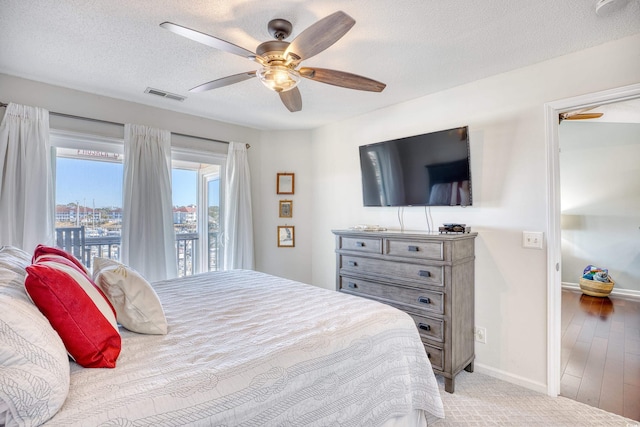 bedroom featuring visible vents, access to outside, a textured ceiling, baseboards, and ceiling fan