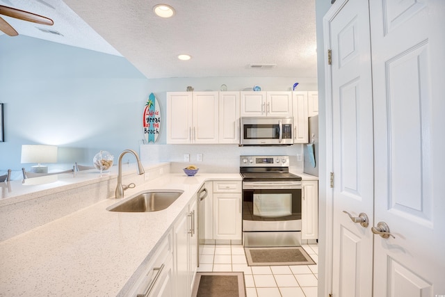 kitchen featuring light tile patterned floors, visible vents, appliances with stainless steel finishes, and a sink