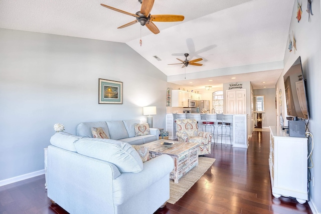 living area featuring visible vents, dark wood-type flooring, baseboards, vaulted ceiling, and a ceiling fan