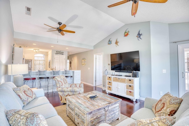 living room with lofted ceiling, wood finished floors, a ceiling fan, and visible vents