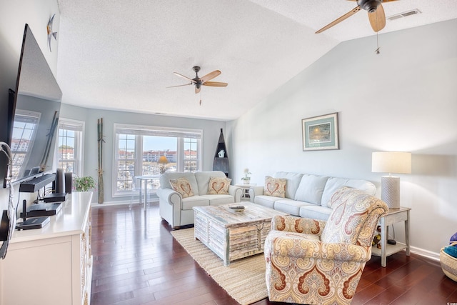 living room featuring visible vents, dark wood-style flooring, ceiling fan, vaulted ceiling, and a textured ceiling