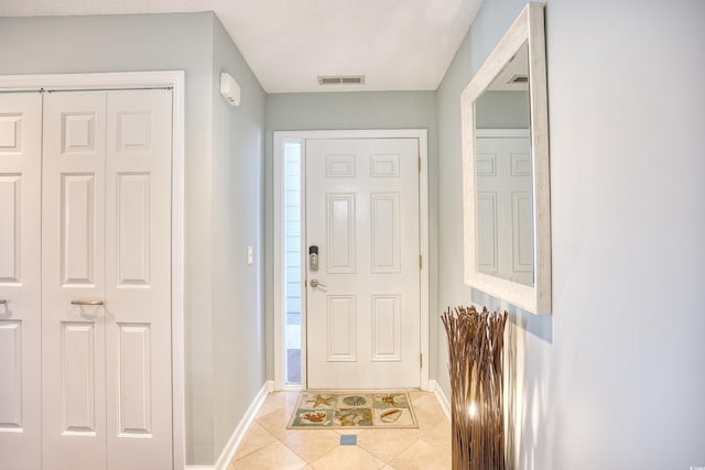 foyer entrance with visible vents, baseboards, and light tile patterned flooring