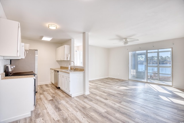 kitchen featuring appliances with stainless steel finishes, sink, white cabinets, and light hardwood / wood-style flooring